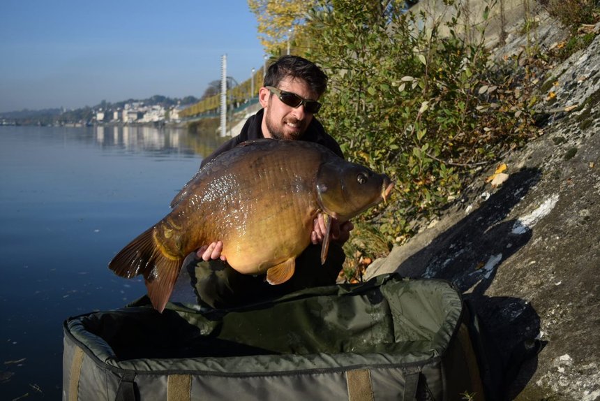 Pêche itinérante de la carpe en automne sur un fleuve urbain