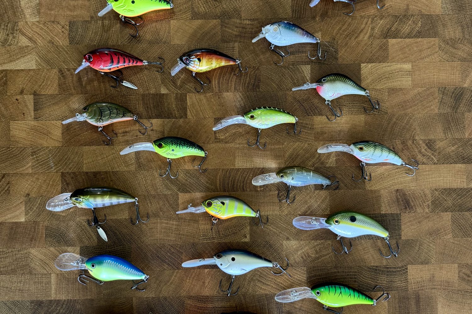 Collection de crankbaits de toutes formes et couleurs alignés sur un plan de travail en bois