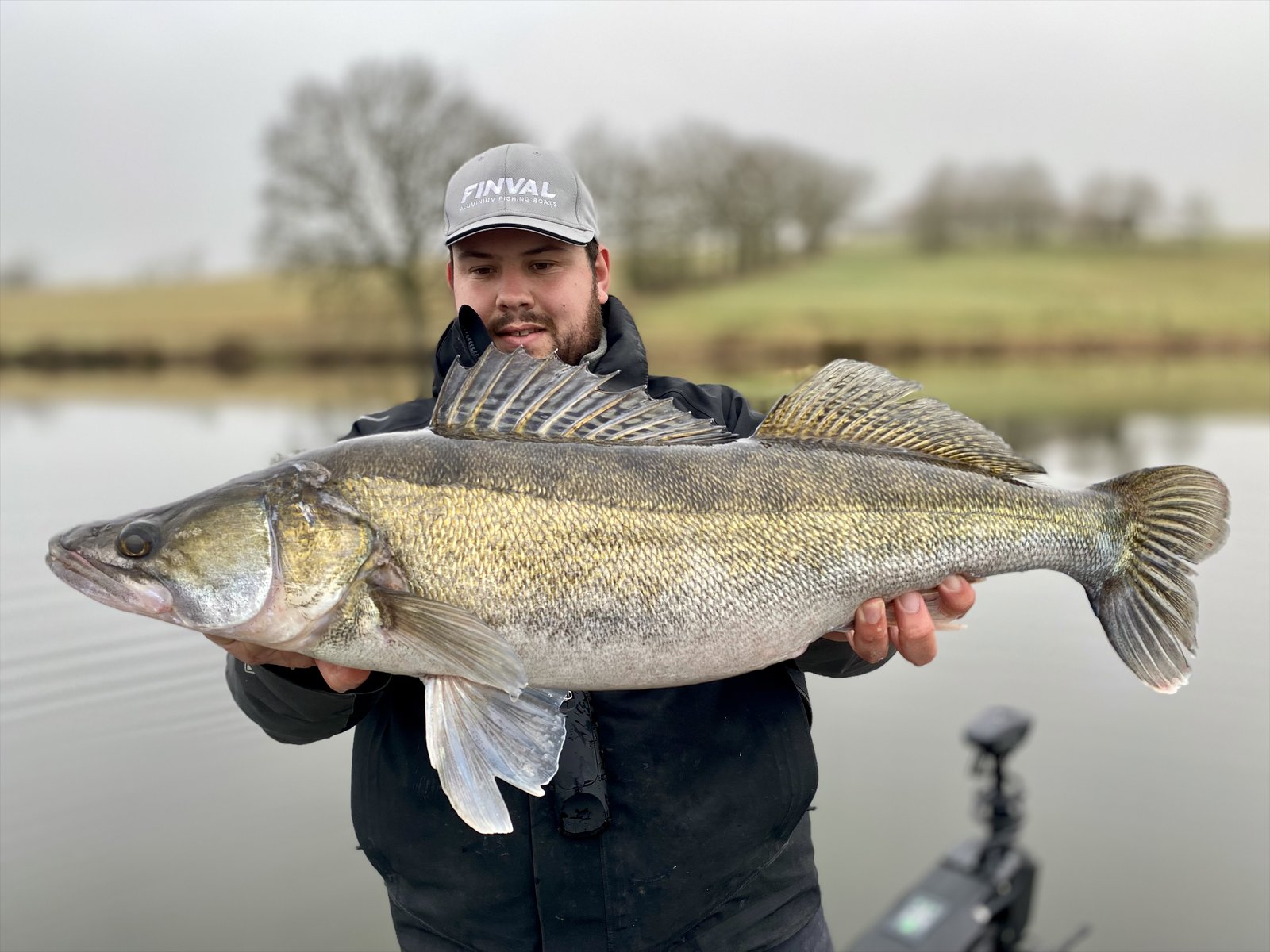 Pêcheur présentant un gros sandre pris sur une grande rivière de Nouvelle-Aquitaine